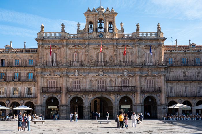 Paseantes ante una de las fachadas de la Plaza Mayor de Salamanca